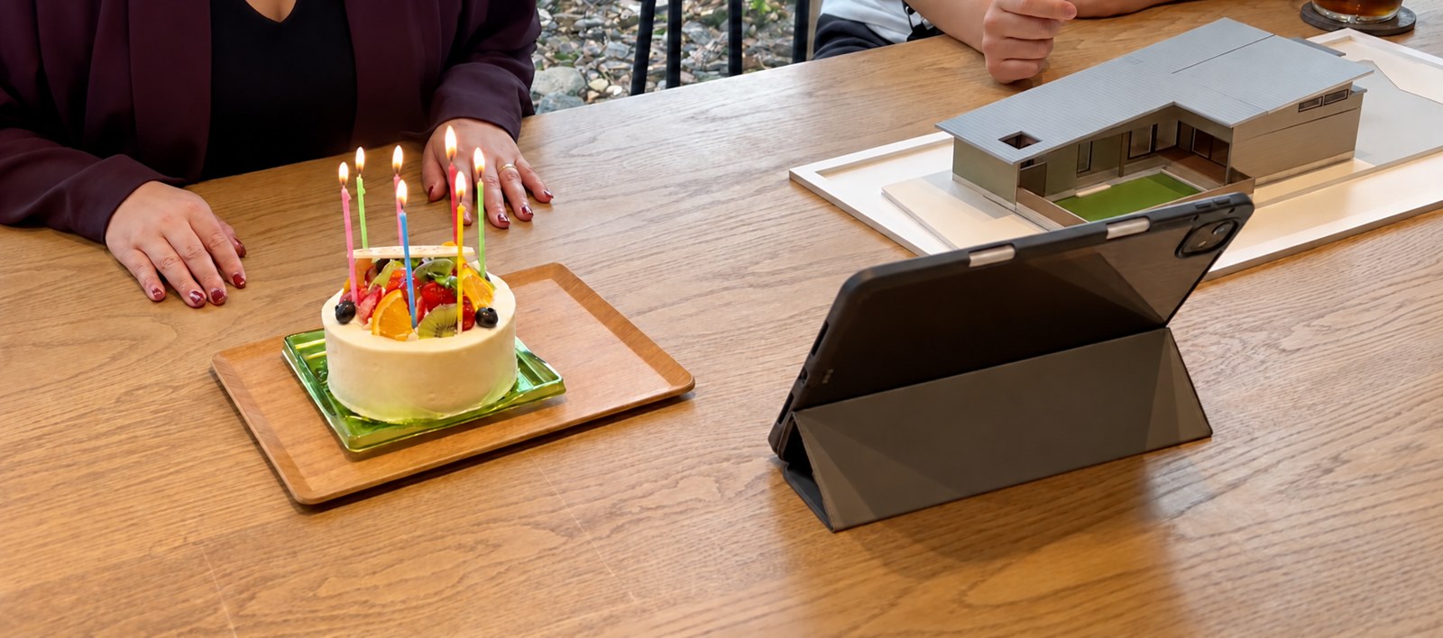 打ち合わせのテーブルで、ケーキを囲んで奥様のお誕生日をお祝いした様子
